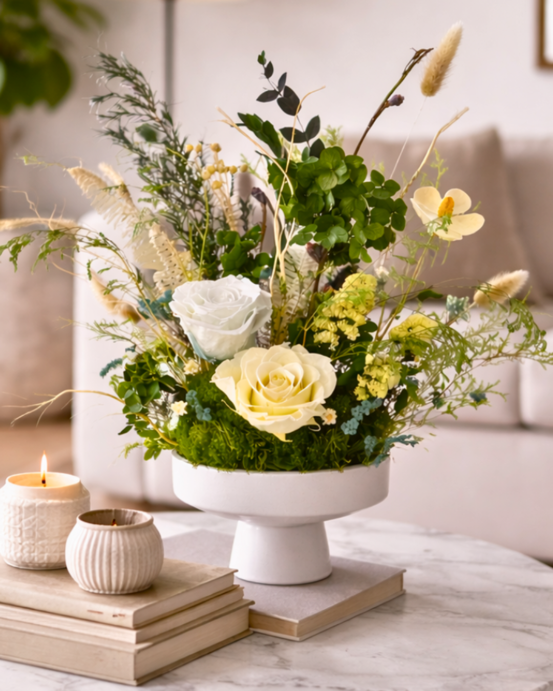 Preserved Floral arrangement in a white vase with candles and books on a table | Fleur Reverie | Texas