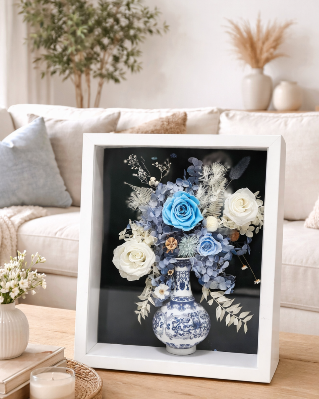 Decorative display of preserved flowers and a vase in a white frame on a table | Fleur Reverie