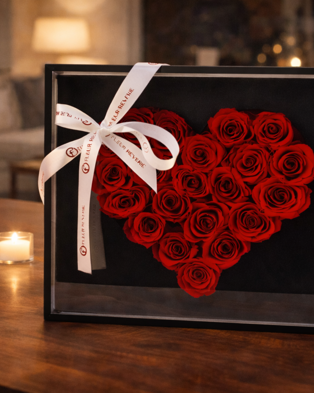 Heart-shaped arrangement of red preserved roses in a black box with a white ribbon on a wooden surface | Fleur Reverie | Austin TX