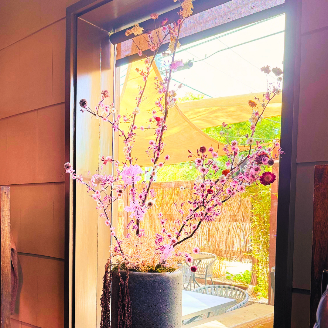 Large size dried flowers in a concrete large planter displayed next to the window