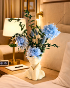 Decorative vase with blue preserved flowers on a nightstand next to a lamp | Fleur Reverie | Austin TX