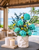 Decorative preserved floral arrangement in a white vase with candles on a table by a poolside | Fleur Reverie | Austin TX