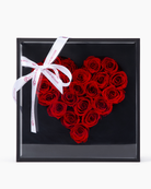Heart-shaped arrangement of preserved red roses in a black box with a white ribbon | Fleur Reverie