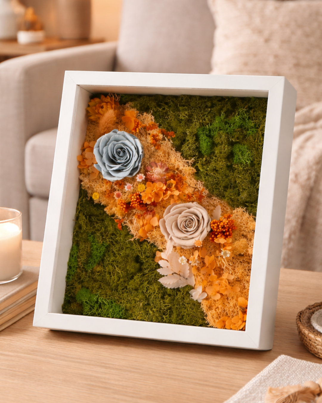 Decorative wall art with flowers and moss in a white frame on a table | Fleur Reveries