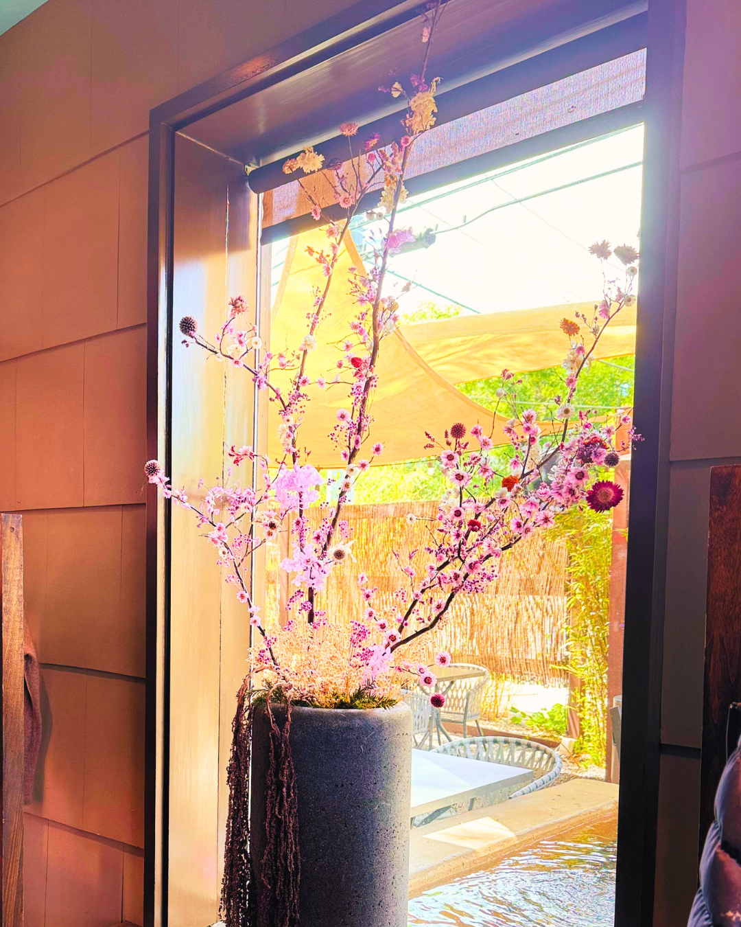 Large size dried flowers in a concrete large planter displayed next to the window