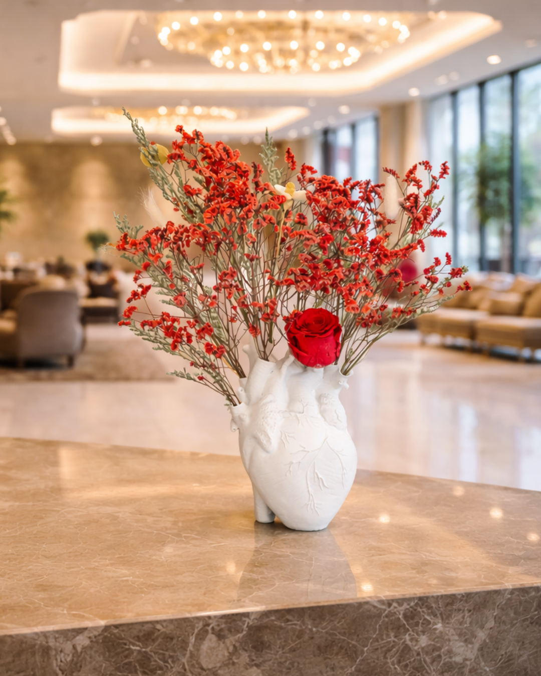 Decorative vase with red dried flowers in anatomical vase on a marble surface | Fleur Reverie | Austin TX