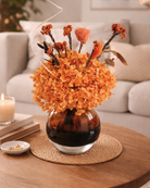 Decorative vase with orange dried flowers on a wooden table in Austin TX | Fleur Reverie