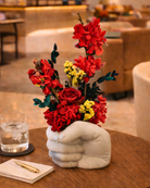 Floral arrangement in a fist-shaped vase on a table in fist vase